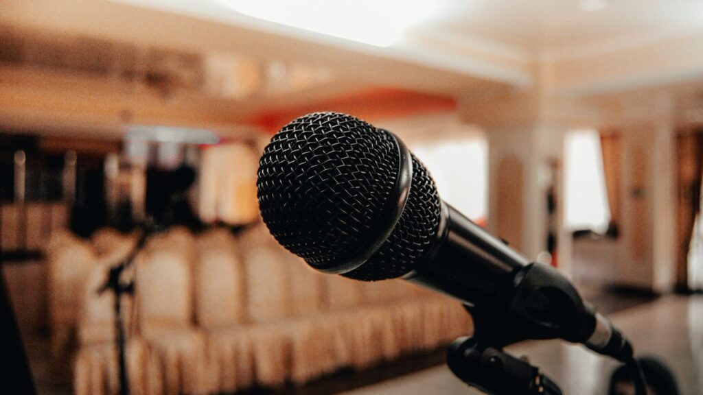 Black microphone in a warmly lit conference hall